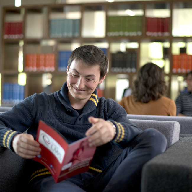 UWS Student in Library Reading about Information for Parents | University of the West of Scotland