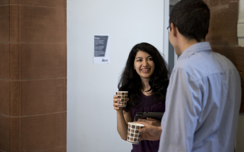 Two students in conversation, drinking coffee