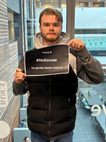 Student holding a sign, "There is #noexcuse for gender-based violence"