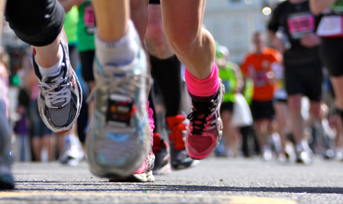 A close-up shot of marathon runners' legs and shoes